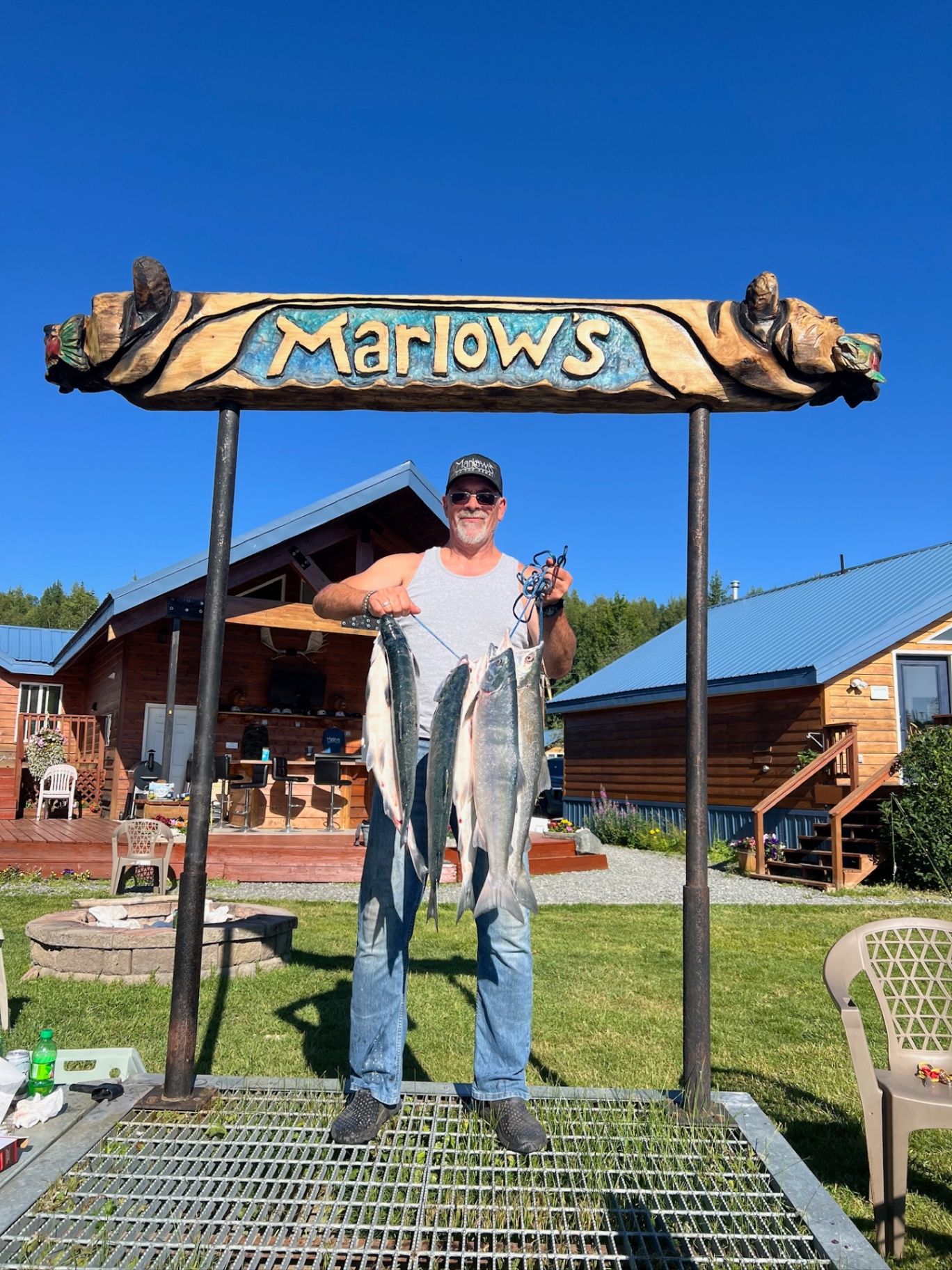Guest with salmon catch at the Marlow's sign