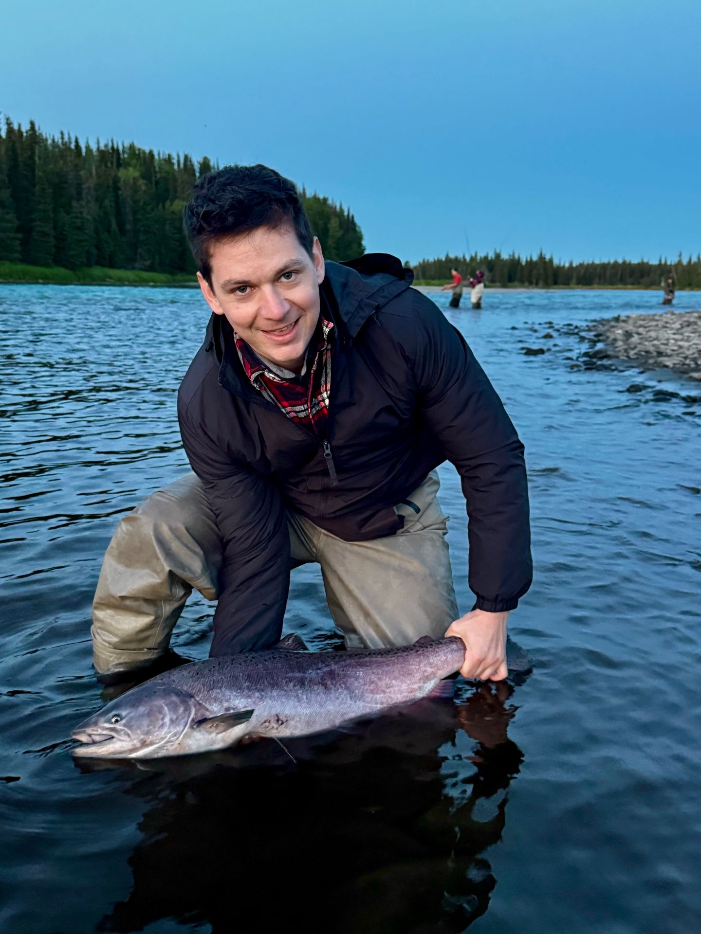 Angler with a beautiful silver salmon at dusk