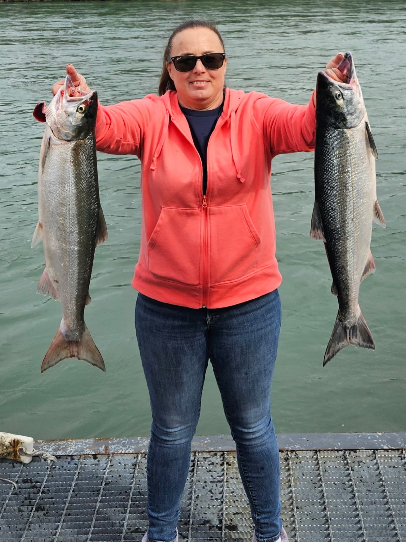 Angler showing off two salmon on the dock