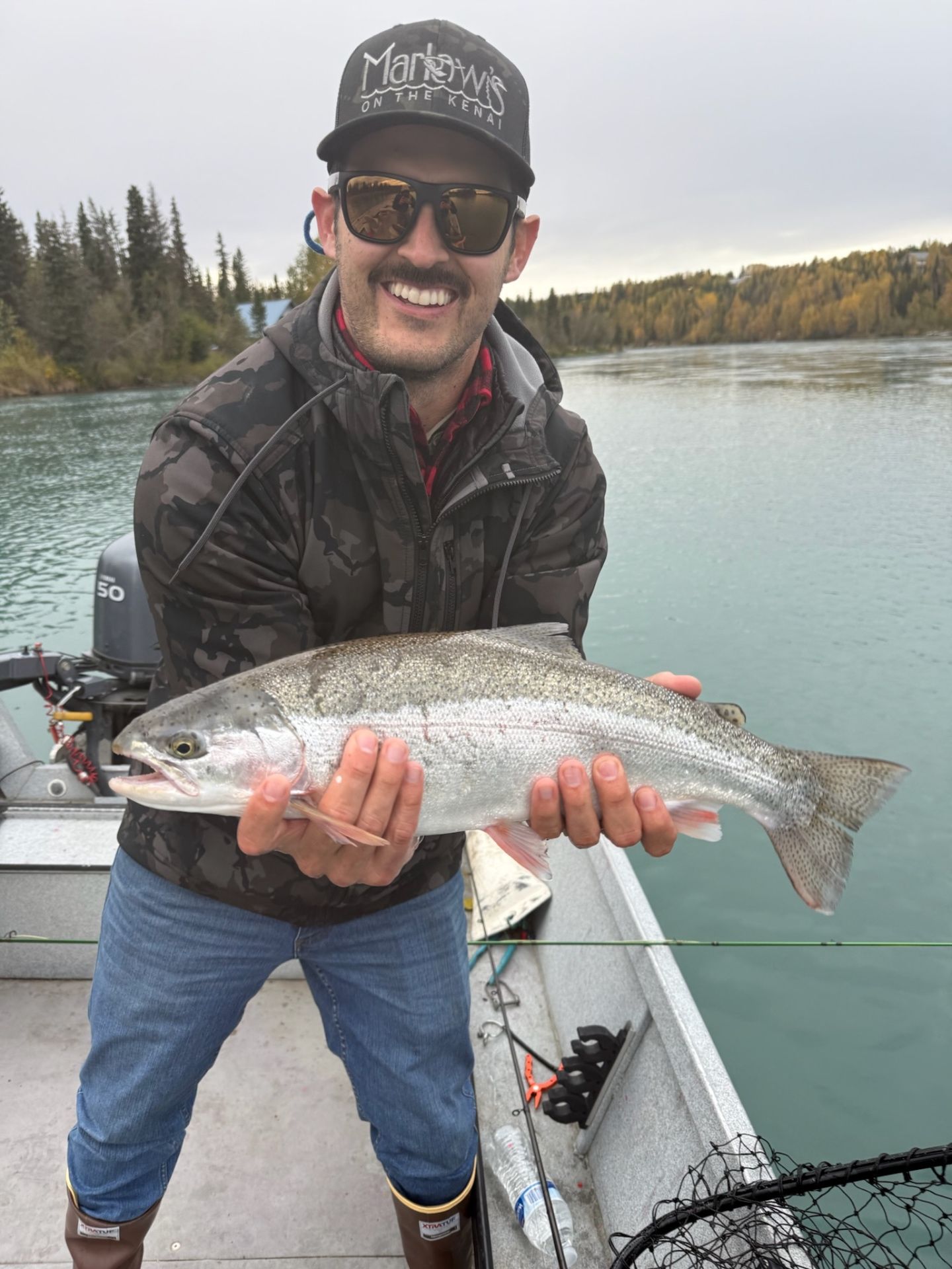 Angler in Marlow's hat with a beautiful rainbow trout on the boat